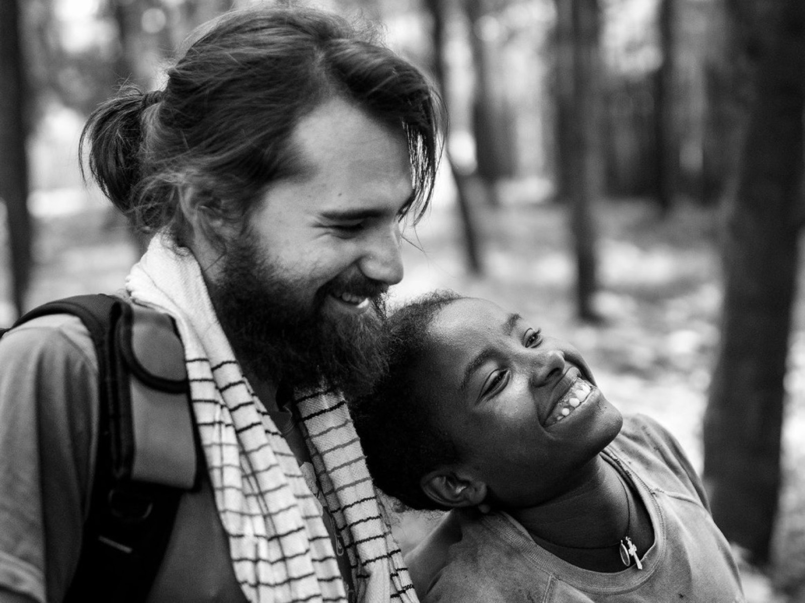 Iñaki Alegría comparte una sonrisa con una niña en una fotografía en blanco y negro