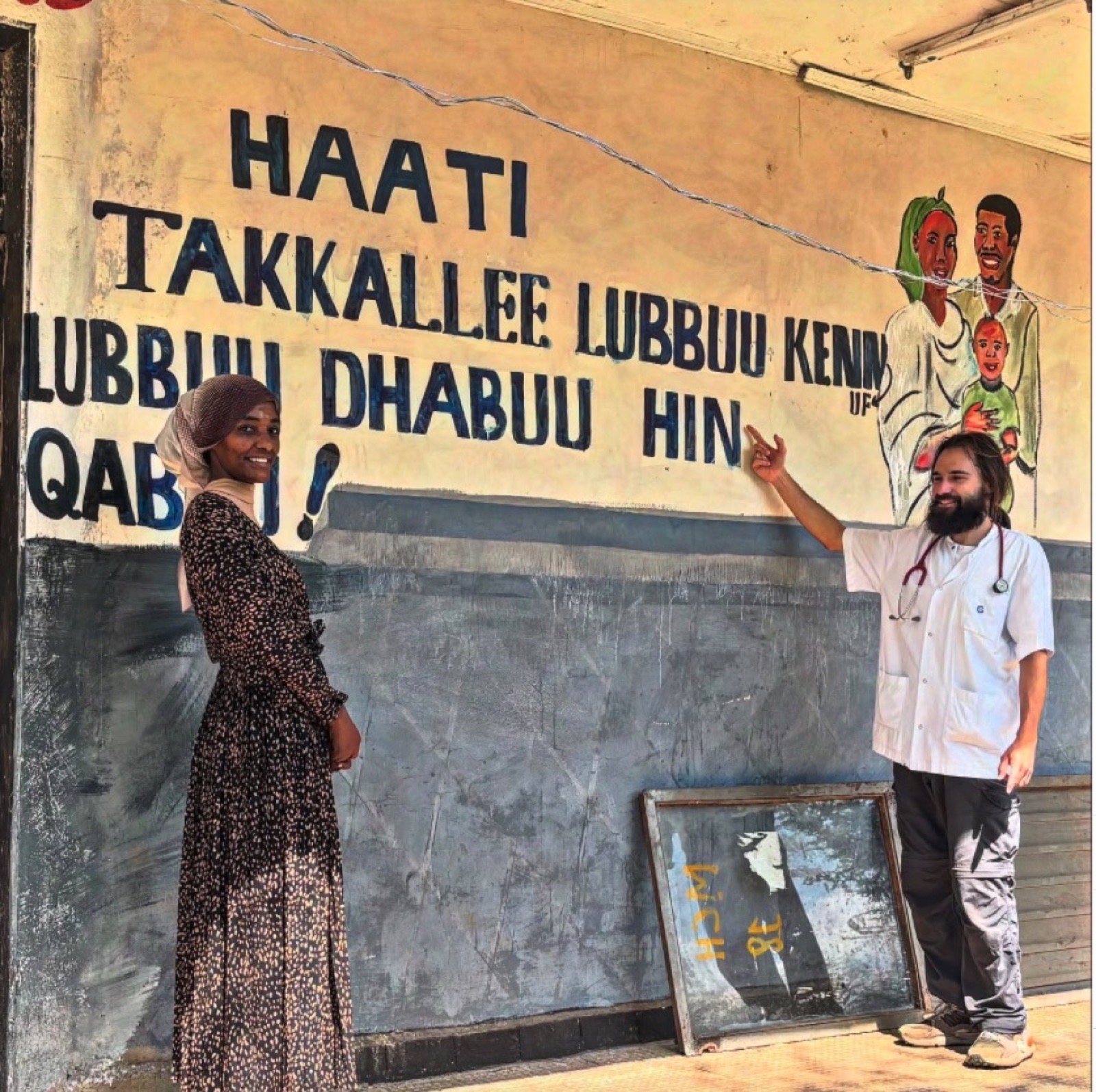 Iñaki Alegría y una profesional junto a un mural de educación sanitaria